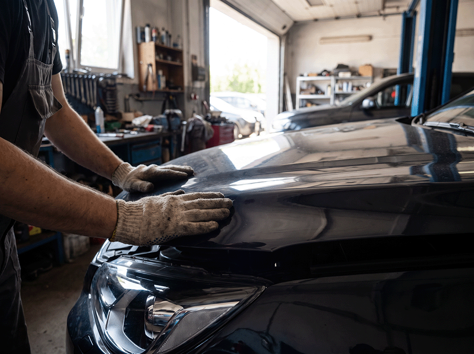 Mechanic closing a car's bonnet after finishing a repair