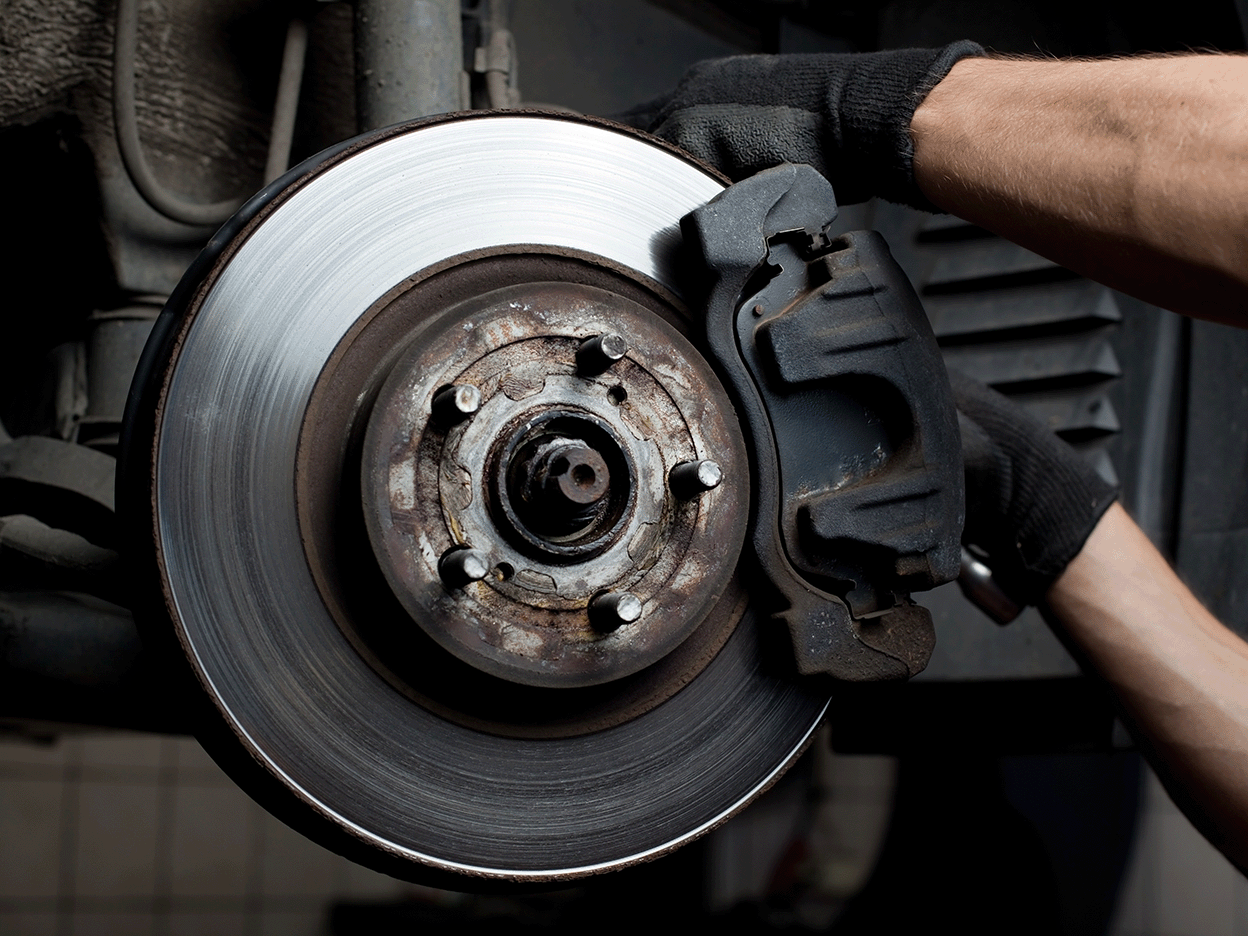 Mechanic servicing a high-performance brake caliper