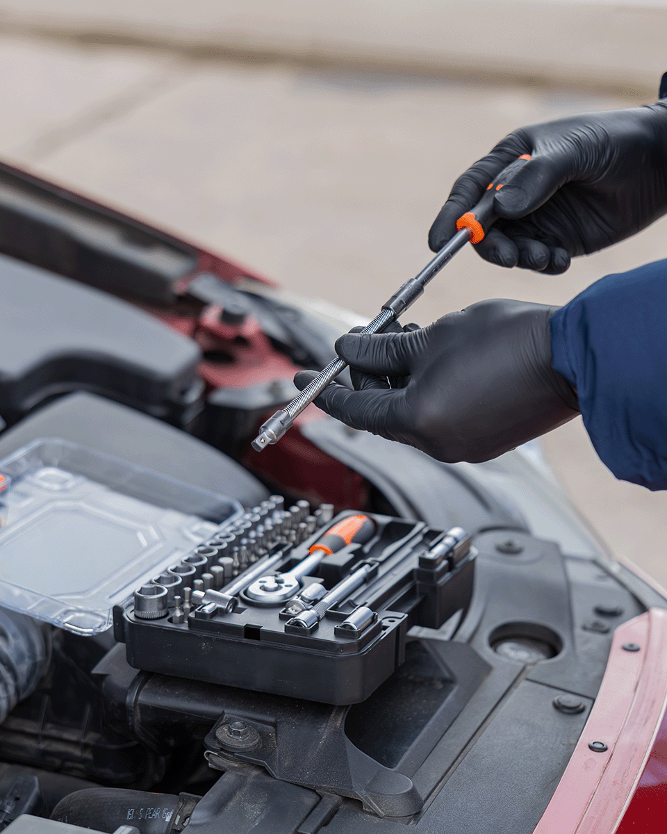 Performance car engine bay being serviced with precision tools laid out